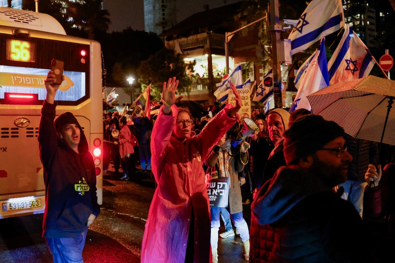 Seorang pengunjuk rasa berdiri di samping spanduk bergambar Perdana Menteri Israel Benjamin Netanyahu saat ia menghadiri rapat umum yang menuntut gencatan senjata segera di Gaza, di tengah konflik yang sedang berlangsung antara Israel dan kelompok Islam Palestina Hamas, di Tel Aviv, Israel, 27 Januari. 2024. Seorang pengunjuk rasa berdiri di samping spanduk bergambar Perdana Menteri Israel Benjamin Netanyahu saat ia menghadiri rapat umum yang menuntut gencatan senjata segera di Gaza, di tengah konflik yang sedang berlangsung antara Israel dan kelompok Islam Palestina Hamas, di Tel Aviv, Israel, 27 Januari. 2024. (REUTERS/Tyrone Siu)