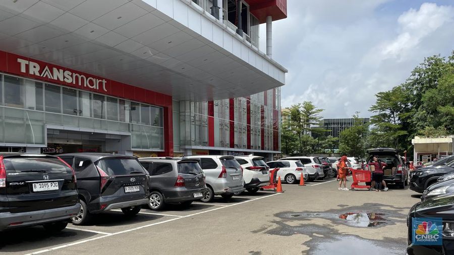 Nampak parkiran Transmart Cempaka Putih dipenuhi kendaraan pengunjung selama Transmart Full Day Sale promo Merdeka Belanja berlangsung pada hari ini Minggu (28/1/2024). (CNBC Indonesia/Mira Rachmalia)