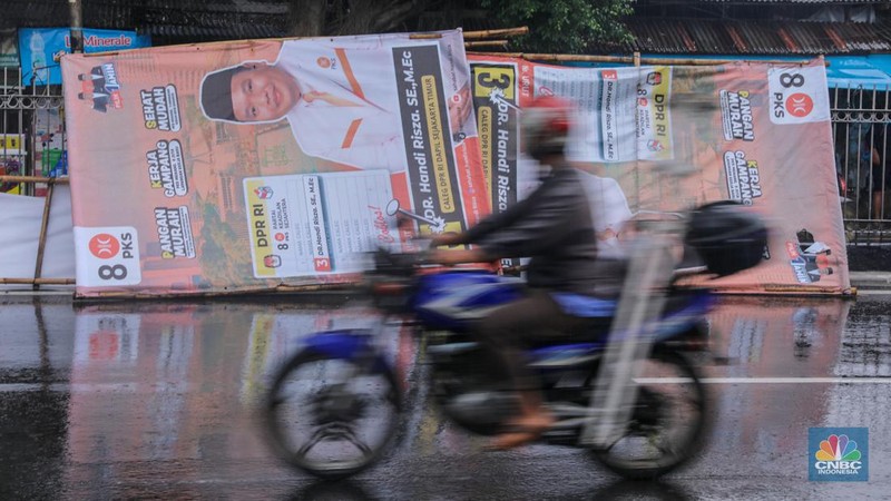 Petugas menertibkan Alat Peraga Kampanye (APK) di kawasan Jalan Raya Bogor, Kramat Jati, Jakarta, Senin (29/1/2024). (CNBC Indonesia/Faisal Rahman)