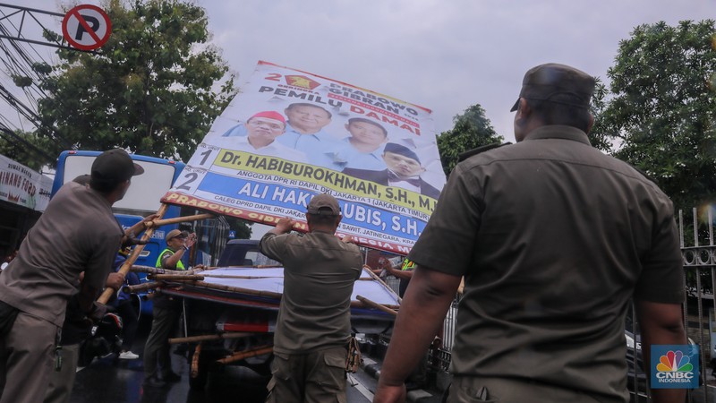 Petugas menertibkan Alat Peraga Kampanye (APK) di kawasan Jalan Raya Bogor, Kramat Jati, Jakarta, Senin (29/1/2024). Petugas menertibkan Alat Peraga Kampanye (APK) di kawasan Jalan Raya Bogor, Kramat Jati, Jakarta, Senin (29/1/2024). (CNBC Indonesia/Faisal Rahman)