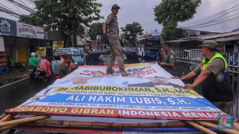 Petugas menertibkan Alat Peraga Kampanye (APK) di kawasan Jalan Raya Bogor, Kramat Jati, Jakarta, Senin (29/1/2024). Petugas menertibkan Alat Peraga Kampanye (APK) di kawasan Jalan Raya Bogor, Kramat Jati, Jakarta, Senin (29/1/2024). (CNBC Indonesia/Faisal Rahman)