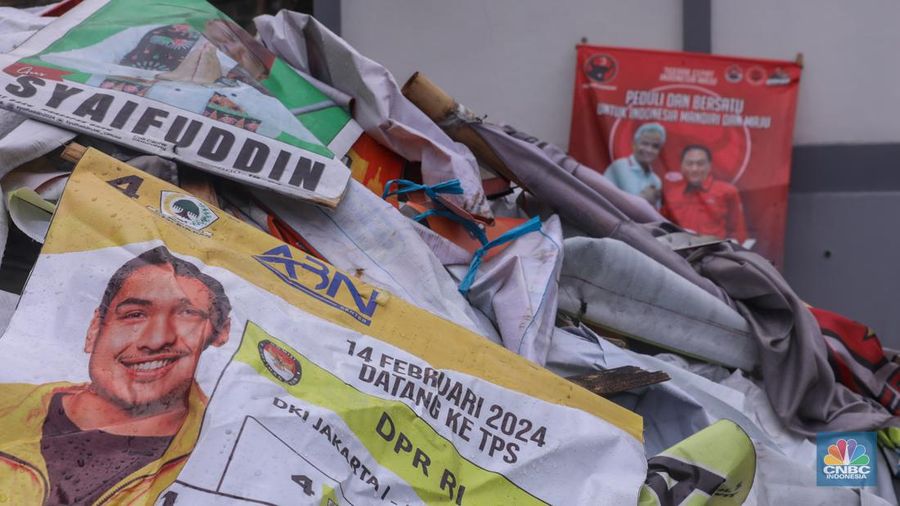 Petugas menertibkan Alat Peraga Kampanye (APK) di kawasan Jalan Raya Bogor, Kramat Jati, Jakarta, Senin (29/1/2024). (CNBC Indonesia/Faisal Rahman)