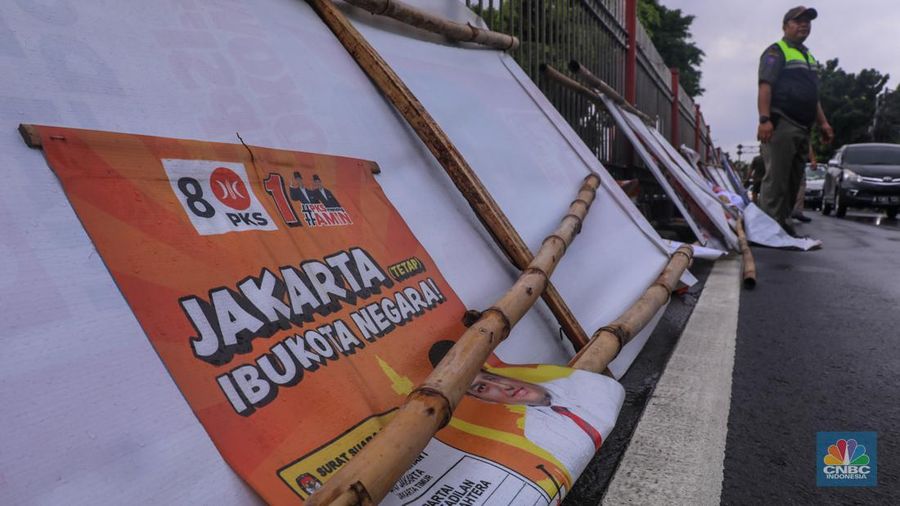 Petugas menertibkan Alat Peraga Kampanye (APK) di kawasan Jalan Raya Bogor, Kramat Jati, Jakarta, Senin (29/1/2024). (CNBC Indonesia/Faisal Rahman)