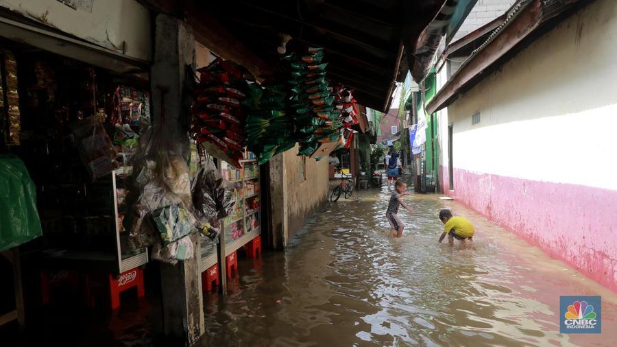 Aktifitas warga saat genangan air melanda di wilayah Cipinang Melayu, Jakarta, (31/1/2024). Pemprov DKI Jakarta melaporkan kenaikan tinggi muka air di Pos Pantau Sunter Hulu usai hujan mengguyur sejumlah wilayah di Jakarta. Pos Sunter Hulu kini statusnya naik menjadi bahaya atau Siaga 1. (CNBC Indonesia/Muhammad Sabki)