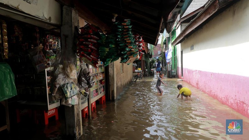 Aktifitas warga saat genangan air melanda di wilayah Cipinang Melayu, Jakarta, (31/1/2024). Pemprov DKI Jakarta melaporkan kenaikan tinggi muka air di Pos Pantau Sunter Hulu usai hujan mengguyur sejumlah wilayah di Jakarta. Pos Sunter Hulu kini statusnya naik menjadi bahaya atau Siaga 1. (CNBC Indonesia/Muhammad Sabki)