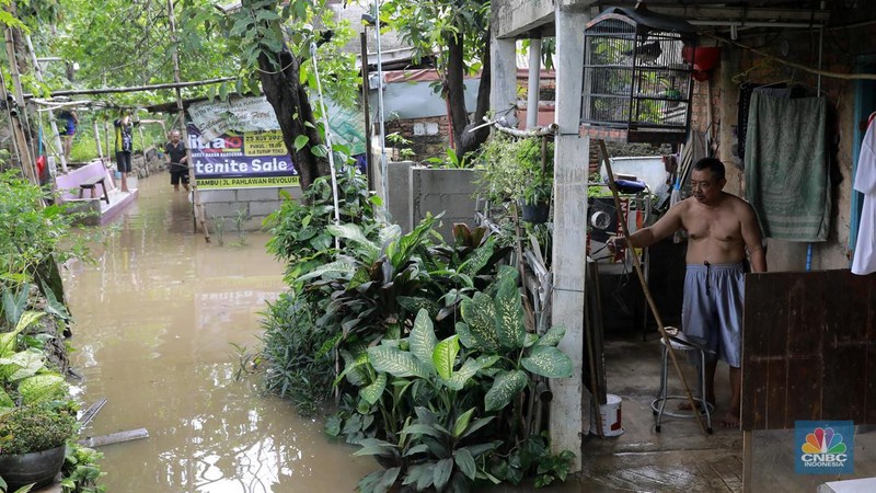 Aktifitas warga saat genangan air melanda di wilayah Cipinang Melayu, Jakarta, (31/1/2024). Pemprov DKI Jakarta melaporkan kenaikan tinggi muka air di Pos Pantau Sunter Hulu usai hujan mengguyur sejumlah wilayah di Jakarta. Pos Sunter Hulu kini statusnya naik menjadi bahaya atau Siaga 1. (CNBC Indonesia/Muhammad Sabki)
