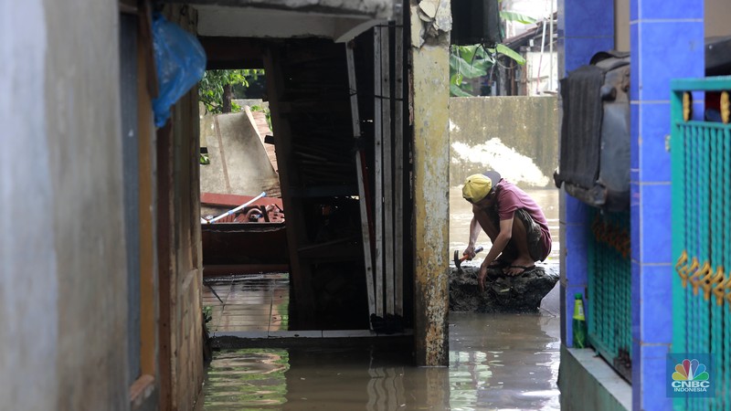 Aktifitas warga saat genangan air melanda di wilayah Cipinang Melayu, Jakarta, (31/1/2024). Pemprov DKI Jakarta melaporkan kenaikan tinggi muka air di Pos Pantau Sunter Hulu usai hujan mengguyur sejumlah wilayah di Jakarta. Pos Sunter Hulu kini statusnya naik menjadi bahaya atau Siaga 1. (CNBC Indonesia/Muhammad Sabki)