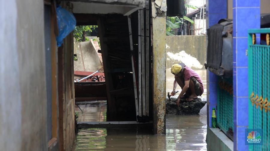 Aktifitas warga saat genangan air melanda di wilayah Cipinang Melayu, Jakarta, (31/1/2024). Pemprov DKI Jakarta melaporkan kenaikan tinggi muka air di Pos Pantau Sunter Hulu usai hujan mengguyur sejumlah wilayah di Jakarta. Pos Sunter Hulu kini statusnya naik menjadi bahaya atau Siaga 1. (CNBC Indonesia/Muhammad Sabki)
