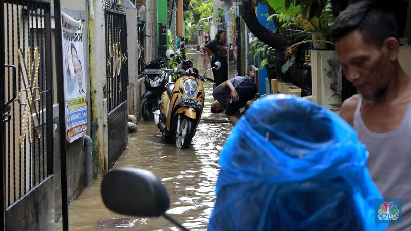 Aktifitas warga saat genangan air melanda di wilayah Cipinang Melayu, Jakarta, (31/1/2024). Pemprov DKI Jakarta melaporkan kenaikan tinggi muka air di Pos Pantau Sunter Hulu usai hujan mengguyur sejumlah wilayah di Jakarta. Pos Sunter Hulu kini statusnya naik menjadi bahaya atau Siaga 1. (CNBC Indonesia/Muhammad Sabki)