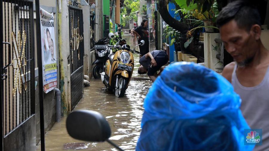 Aktifitas warga saat genangan air melanda di wilayah Cipinang Melayu, Jakarta, (31/1/2024). Pemprov DKI Jakarta melaporkan kenaikan tinggi muka air di Pos Pantau Sunter Hulu usai hujan mengguyur sejumlah wilayah di Jakarta. Pos Sunter Hulu kini statusnya naik menjadi bahaya atau Siaga 1. (CNBC Indonesia/Muhammad Sabki)