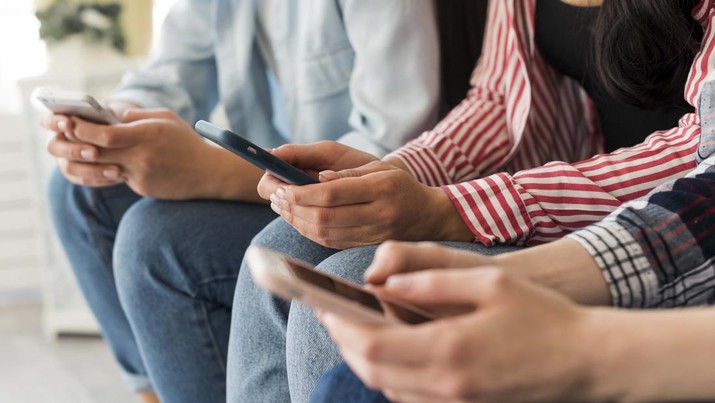 Ilustrasi orang bermain handphone. (Getty Images/filadendron)