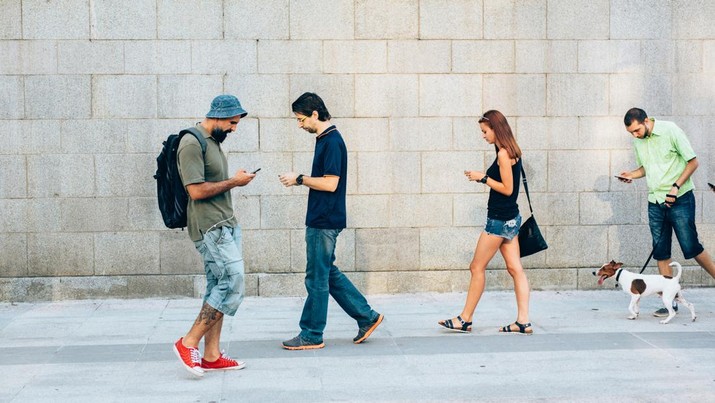 Ilustrasi orang bermain handphone. (Getty Images/filadendron)