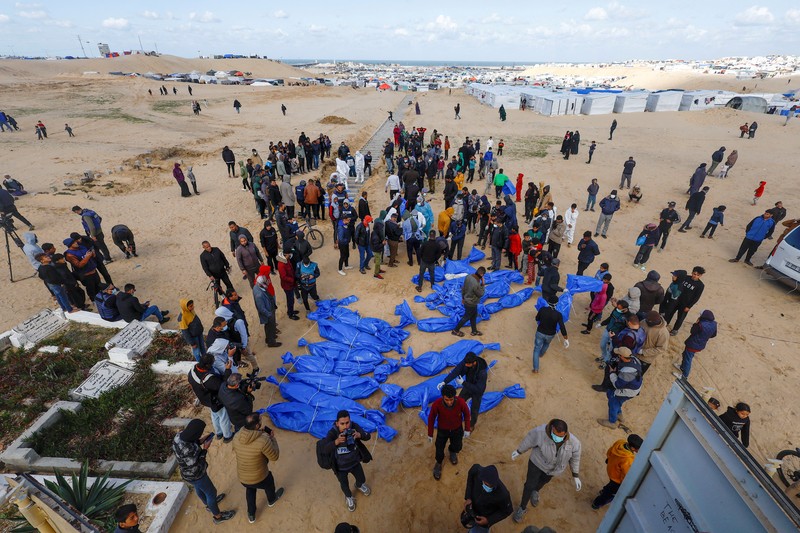 Warga Palestina menguburkan jenazah orang yang tewas dalam pertempuran dengan Israel dan dikembalikan ke Gaza oleh militer Israel, saat pemakaman massal di Rafah, Jalur Gaza, Selasa, 30 Januari 2024. Warga Palestina menguburkan jenazah orang yang tewas dalam pertempuran dengan Israel dan dikembalikan ke Gaza oleh militer Israel, saat pemakaman massal di Rafah, Jalur Gaza, Selasa, 30 Januari 2024. (AP Photo/Fatima Shbair)