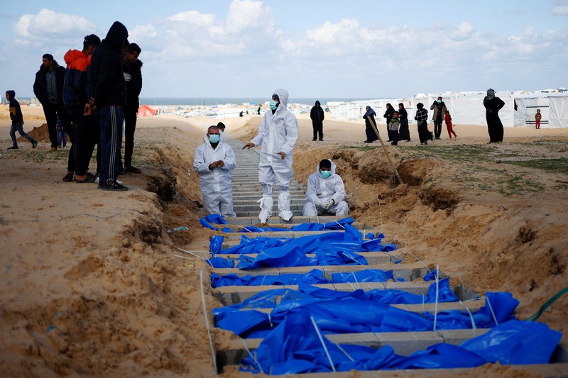 Warga Palestina menguburkan jenazah orang yang tewas dalam pertempuran dengan Israel dan dikembalikan ke Gaza oleh militer Israel, saat pemakaman massal di Rafah, Jalur Gaza, Selasa, 30 Januari 2024. Warga Palestina menguburkan jenazah orang yang tewas dalam pertempuran dengan Israel dan dikembalikan ke Gaza oleh militer Israel, saat pemakaman massal di Rafah, Jalur Gaza, Selasa, 30 Januari 2024. (AP Photo/Fatima Shbair)