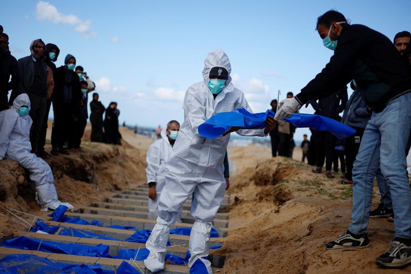 Warga Palestina menguburkan jenazah orang yang tewas dalam pertempuran dengan Israel dan dikembalikan ke Gaza oleh militer Israel, saat pemakaman massal di Rafah, Jalur Gaza, Selasa, 30 Januari 2024. Warga Palestina menguburkan jenazah orang yang tewas dalam pertempuran dengan Israel dan dikembalikan ke Gaza oleh militer Israel, saat pemakaman massal di Rafah, Jalur Gaza, Selasa, 30 Januari 2024. (AP Photo/Fatima Shbair)