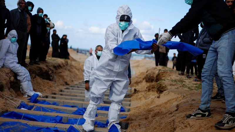 Warga Palestina menguburkan jenazah orang yang tewas dalam pertempuran dengan Israel dan dikembalikan ke Gaza oleh militer Israel, saat pemakaman massal di Rafah, Jalur Gaza, Selasa, 30 Januari 2024. (AP Photo/Fatima Shbair)