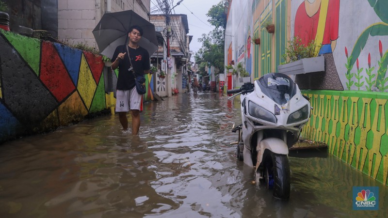 Warga melintas saat banjir melanda wilayah pemukiman penduduk di kawasan Petogogan, Jakarta, Rabu (31/1/2024). Banjir yang melanda wilayah yang berlokasi tidak jauh dari kantor Walikota Jakarta Selatan itu terjadi akibat hujan sejak pukul 01.00 WIB dini hari. (CNBC Indonesia/Faisal Rahman)