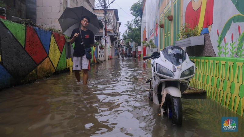 Warga melintas saat banjir melanda wilayah pemukiman penduduk di kawasan Petogogan, Jakarta, Rabu (31/1/2024). Banjir yang melanda wilayah yang berlokasi tidak jauh dari kantor Walikota Jakarta Selatan itu terjadi akibat hujan sejak pukul 01.00 WIB dini hari. (CNBC Indonesia/Faisal Rahman)