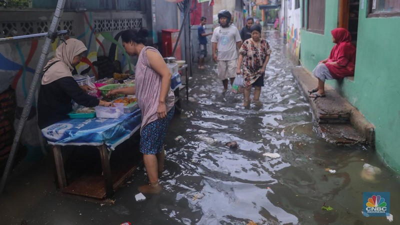 Warga melintas saat banjir melanda wilayah pemukiman penduduk di kawasan Petogogan, Jakarta, Rabu (31/1/2024). Banjir yang melanda wilayah yang berlokasi tidak jauh dari kantor Walikota Jakarta Selatan itu terjadi akibat hujan sejak pukul 01.00 WIB dini hari. (CNBC Indonesia/Faisal Rahman)
