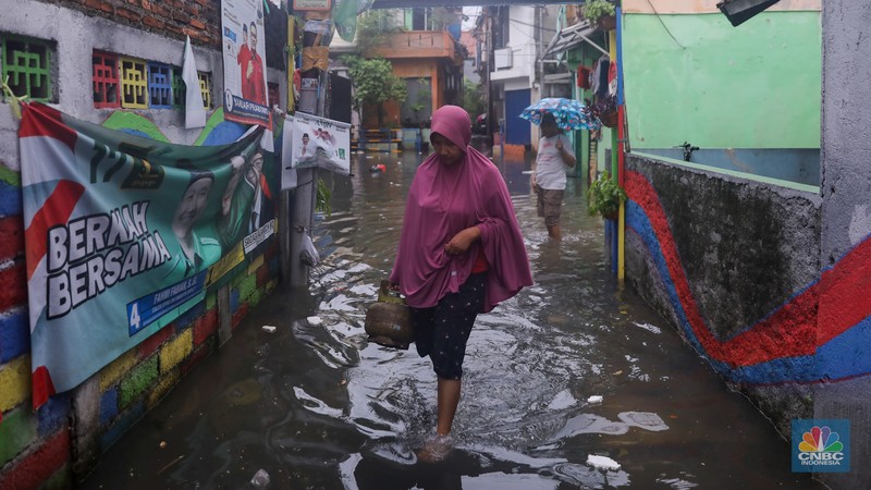Warga melintas saat banjir melanda wilayah pemukiman penduduk di kawasan Petogogan, Jakarta, Rabu (31/1/2024). Banjir yang melanda wilayah yang berlokasi tidak jauh dari kantor Walikota Jakarta Selatan itu terjadi akibat hujan sejak pukul 01.00 WIB dini hari. (CNBC Indonesia/Faisal Rahman)