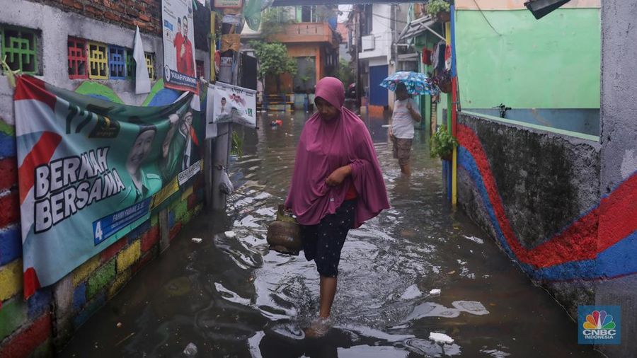 Warga melintas saat banjir melanda wilayah pemukiman penduduk di kawasan Petogogan, Jakarta, Rabu (31/1/2024). Banjir yang melanda wilayah yang berlokasi tidak jauh dari kantor Walikota Jakarta Selatan itu terjadi akibat hujan sejak pukul 01.00 WIB dini hari. (CNBC Indonesia/Faisal Rahman)
