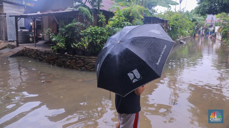 Warga melintas saat banjir melanda wilayah pemukiman penduduk di kawasan Petogogan, Jakarta, Rabu (31/1/2024). Banjir yang melanda wilayah yang berlokasi tidak jauh dari kantor Walikota Jakarta Selatan itu terjadi akibat hujan sejak pukul 01.00 WIB dini hari. (CNBC Indonesia/Faisal Rahman)