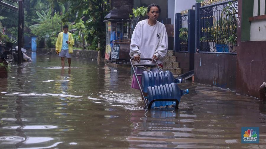 Warga melintas saat banjir melanda wilayah pemukiman penduduk di kawasan Petogogan, Jakarta, Rabu (31/1/2024). Banjir yang melanda wilayah yang berlokasi tidak jauh dari kantor Walikota Jakarta Selatan itu terjadi akibat hujan sejak pukul 01.00 WIB dini hari. (CNBC Indonesia/Faisal Rahman)