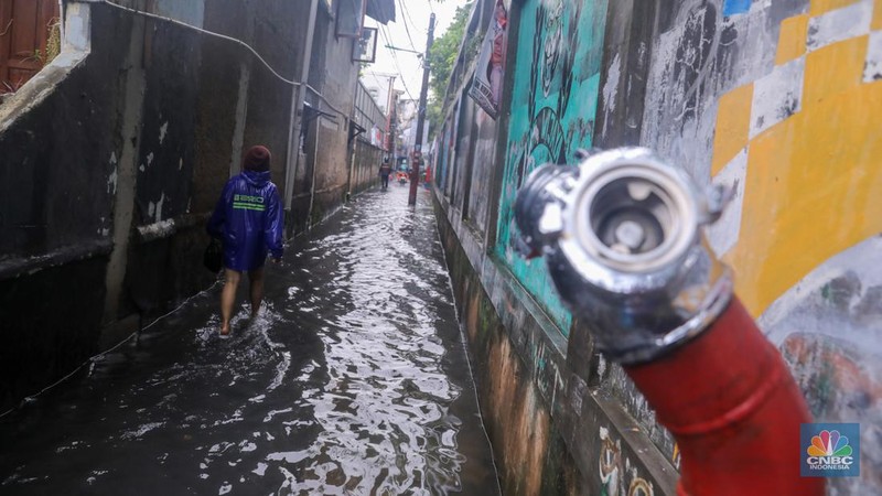 Warga melintas saat banjir melanda wilayah pemukiman penduduk di kawasan Petogogan, Jakarta, Rabu (31/1/2024). Banjir yang melanda wilayah yang berlokasi tidak jauh dari kantor Walikota Jakarta Selatan itu terjadi akibat hujan sejak pukul 01.00 WIB dini hari. (CNBC Indonesia/Faisal Rahman)