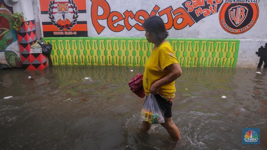 Warga melintas saat banjir melanda wilayah pemukiman penduduk di kawasan Petogogan, Jakarta, Rabu (31/1/2024). Banjir yang melanda wilayah yang berlokasi tidak jauh dari kantor Walikota Jakarta Selatan itu terjadi akibat hujan sejak pukul 01.00 WIB dini hari. (CNBC Indonesia/Faisal Rahman)