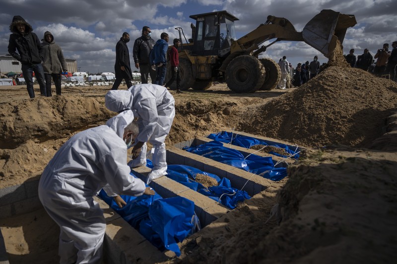 Warga Palestina menguburkan jenazah orang yang tewas dalam pertempuran dengan Israel dan dikembalikan ke Gaza oleh militer Israel, saat pemakaman massal di Rafah, Jalur Gaza, Selasa, 30 Januari 2024. (AP Photo/Fatima Shbair)