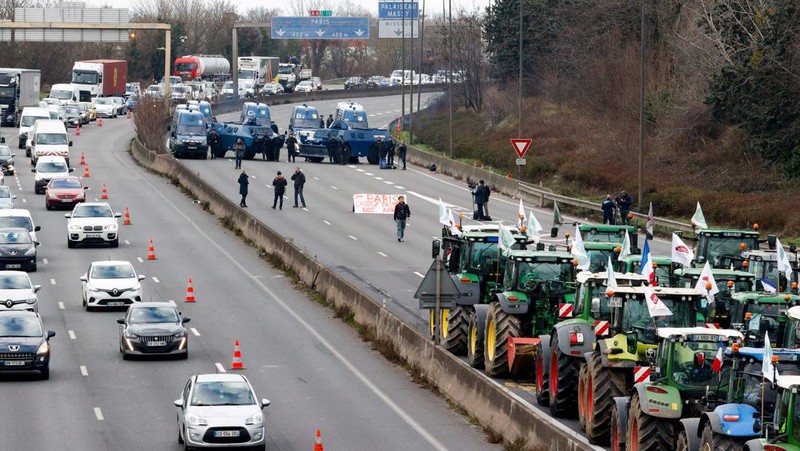 Asap mengepul dari benda-benda yang dibakar ketika orang-orang berkumpul di depan kantor pusat Uni Eropa ketika para petani Belgia menggunakan traktor mereka untuk memblokir kantor pusat, ketika mereka memprotes tekanan harga, pajak dan peraturan ramah lingkungan, keluhan yang dirasakan oleh para petani di seluruh Eropa, di Brussels, Belgia 1 Februari 2024. (REUTERS/Yves Herman)