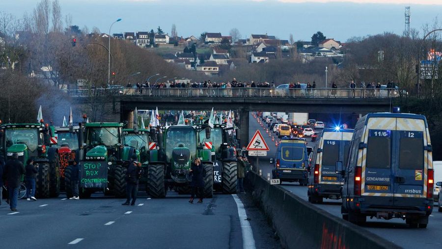 Asap mengepul dari benda-benda yang dibakar ketika orang-orang berkumpul di depan kantor pusat Uni Eropa ketika para petani Belgia menggunakan traktor mereka untuk memblokir kantor pusat, ketika mereka memprotes tekanan harga, pajak dan peraturan ramah lingkungan, keluhan yang dirasakan oleh para petani di seluruh Eropa, di Brussels, Belgia 1 Februari 2024. (REUTERS/Yves Herman)