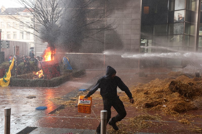 Asap mengepul dari benda-benda yang dibakar ketika orang-orang berkumpul di depan kantor pusat Uni Eropa ketika para petani Belgia menggunakan traktor mereka untuk memblokir kantor pusat, ketika mereka memprotes tekanan harga, pajak dan peraturan ramah lingkungan, keluhan yang dirasakan oleh para petani di seluruh Eropa, di Brussels, Belgia 1 Februari 2024. Asap mengepul dari benda-benda yang dibakar ketika orang-orang berkumpul di depan kantor pusat Uni Eropa ketika para petani Belgia menggunakan traktor mereka untuk memblokir kantor pusat, ketika mereka memprotes tekanan harga, pajak dan peraturan ramah lingkungan, keluhan yang dirasakan oleh para petani di seluruh Eropa, di Brussels, Belgia 1 Februari 2024. (REUTERS/Yves Herman)