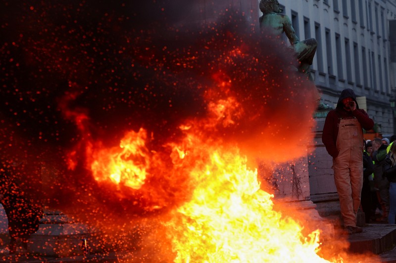 Asap mengepul dari benda-benda yang dibakar ketika orang-orang berkumpul di depan kantor pusat Uni Eropa ketika para petani Belgia menggunakan traktor mereka untuk memblokir kantor pusat, ketika mereka memprotes tekanan harga, pajak dan peraturan ramah lingkungan, keluhan yang dirasakan oleh para petani di seluruh Eropa, di Brussels, Belgia 1 Februari 2024. Asap mengepul dari benda-benda yang dibakar ketika orang-orang berkumpul di depan kantor pusat Uni Eropa ketika para petani Belgia menggunakan traktor mereka untuk memblokir kantor pusat, ketika mereka memprotes tekanan harga, pajak dan peraturan ramah lingkungan, keluhan yang dirasakan oleh para petani di seluruh Eropa, di Brussels, Belgia 1 Februari 2024. (REUTERS/Yves Herman)