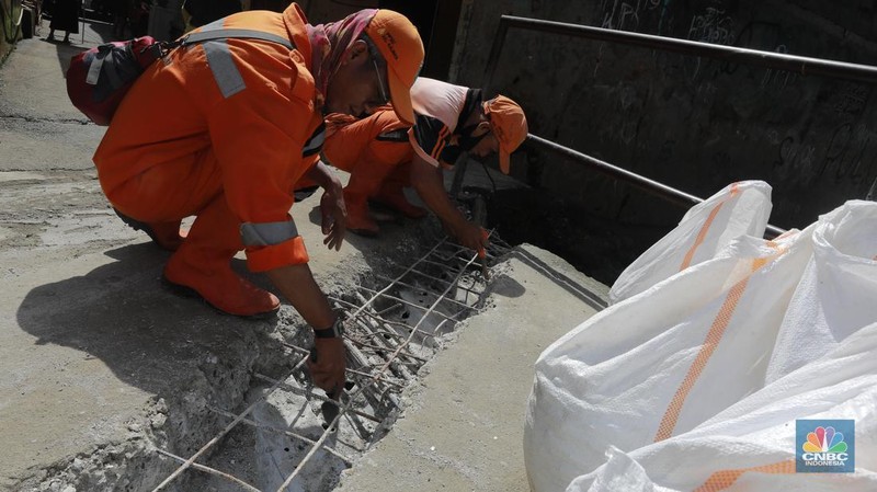 Petugas membongkar jembatan di kawasan Kali Sarua, Pejaten Barat, Jakarta, Jumat, (2/2/2024). Normalisasi Kali Sarua ini untuk mengatasi banjir di wilayah itu. Setidaknya ada lebih dari 2.000 keluarga yang terdampak banjir imbas meluapnya Kali Sarua. (վ/Muhammad Sabki)