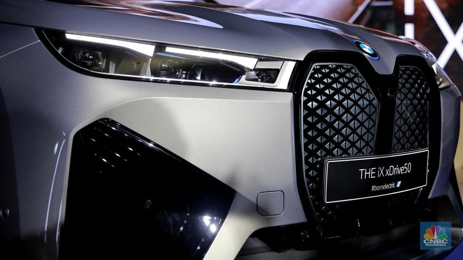 Seorang model berpose di samping mobil keluaran BMW keluaran terbaru di Ritz Carlton, Kuningan, Jakarta, Jumat, (2/2/2024). (CNBC Indonesia/Muhammad Sabki)
