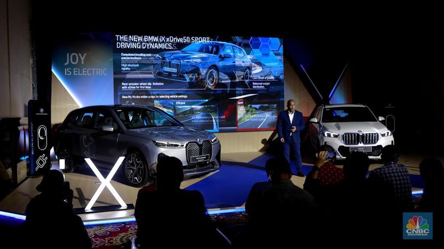 Seorang model berpose di samping mobil keluaran BMW keluaran terbaru di Ritz Carlton, Kuningan, Jakarta, Jumat, (2/2/2024). (CNBC Indonesia/Muhammad Sabki)