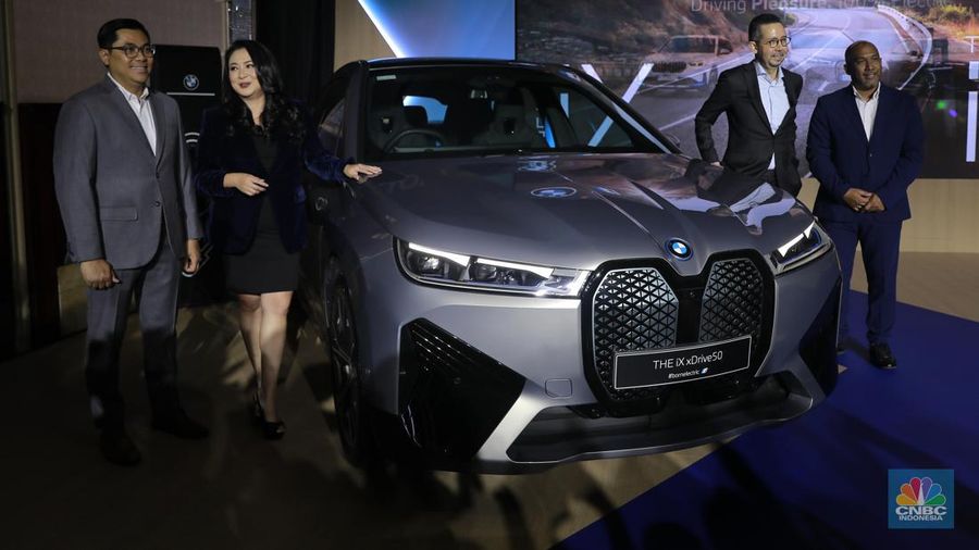 Seorang model berpose di samping mobil keluaran BMW keluaran terbaru di Ritz Carlton, Kuningan, Jakarta, Jumat, (2/2/2024). (CNBC Indonesia/Muhammad Sabki)