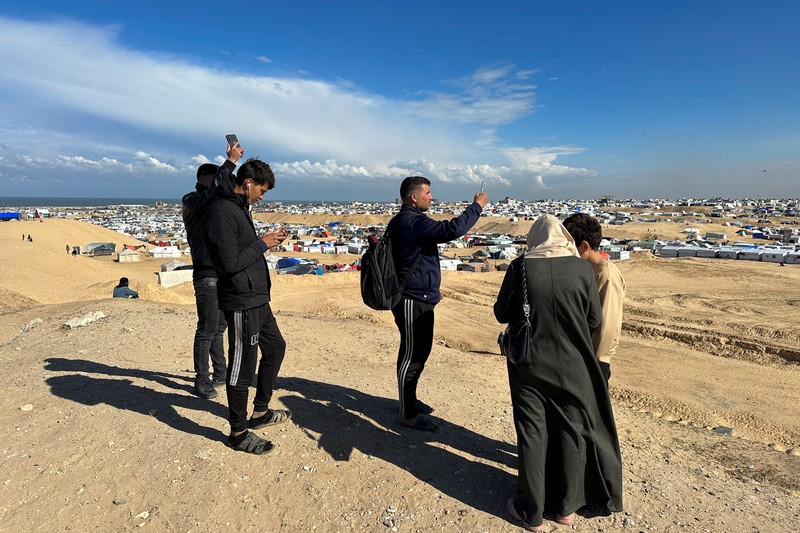 Warga Gaza mencari sinyal seluler hingga perbatasan Mesir. (REUTERS/Mohammed Salem)
