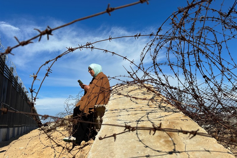 Warga Gaza mencari sinyal seluler hingga perbatasan Mesir. (REUTERS/Mohammed Salem)