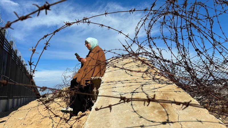 Warga Gaza mencari sinyal seluler hingga perbatasan Mesir. (REUTERS/Mohammed Salem)