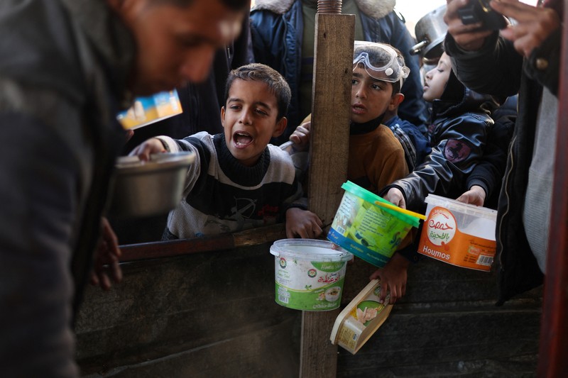 Sejumlah anak antre untuk menerima makanan pada dapur umum pengungsian di Rafah, Selatan Jalur Gaza, Senin (5/2/2024). (REUTERS/Ibraheem Abu Mustafa) Sejumlah anak antre untuk menerima makanan pada dapur umum pengungsian di Rafah, Selatan Jalur Gaza, Senin (5/2/2024). (REUTERS/Ibraheem Abu Mustafa)