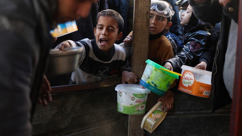 Sejumlah anak antre untuk menerima makanan pada dapur umum pengungsian di Rafah, Selatan Jalur Gaza, Senin (5/2/2024). (REUTERS/Ibraheem Abu Mustafa)