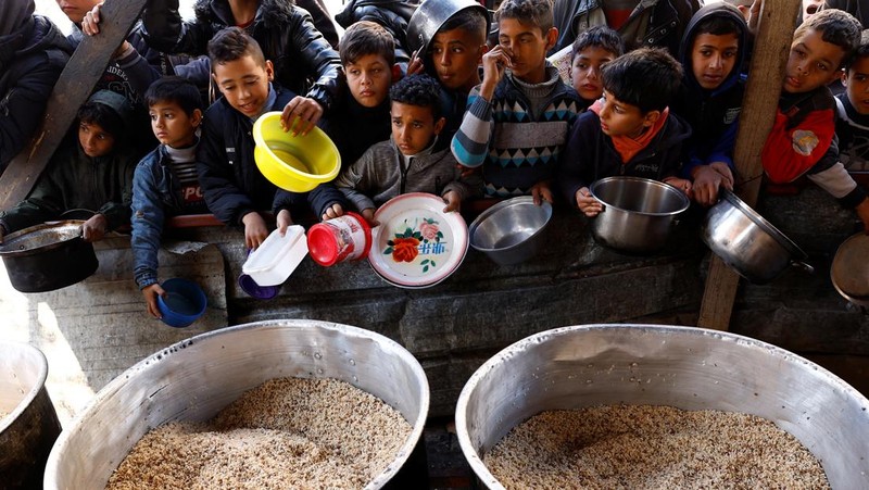 Sejumlah anak antre untuk menerima makanan pada dapur umum pengungsian di Rafah, Selatan Jalur Gaza, Senin (5/2/2024). (REUTERS/Ibraheem Abu Mustafa)