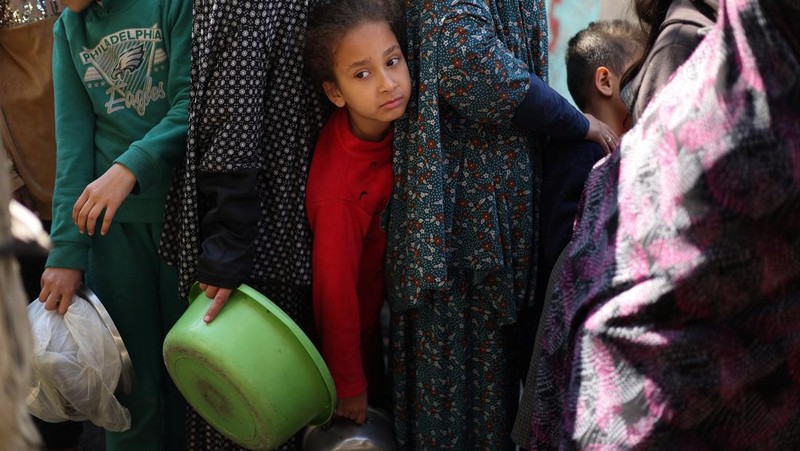 Sejumlah anak antre untuk menerima makanan pada dapur umum pengungsian di Rafah, Selatan Jalur Gaza, Senin (5/2/2024). (REUTERS/Ibraheem Abu Mustafa)