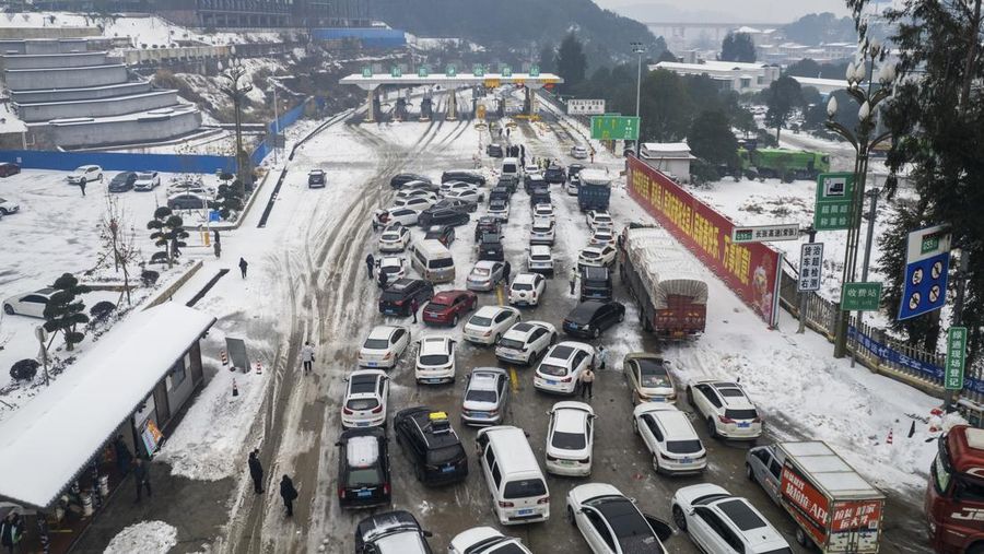 Orang-orang mendorong mobil yang terjebak di jalan raya setelah hujan salju lebat di wilayah tersebut, selama kesibukan perjalanan Festival Musim Semi menjelang Tahun Baru Imlek, di Wuhan, provinsi Hubei, Tiongkok 6 Februari 2024. (China Daily via REUTERS)