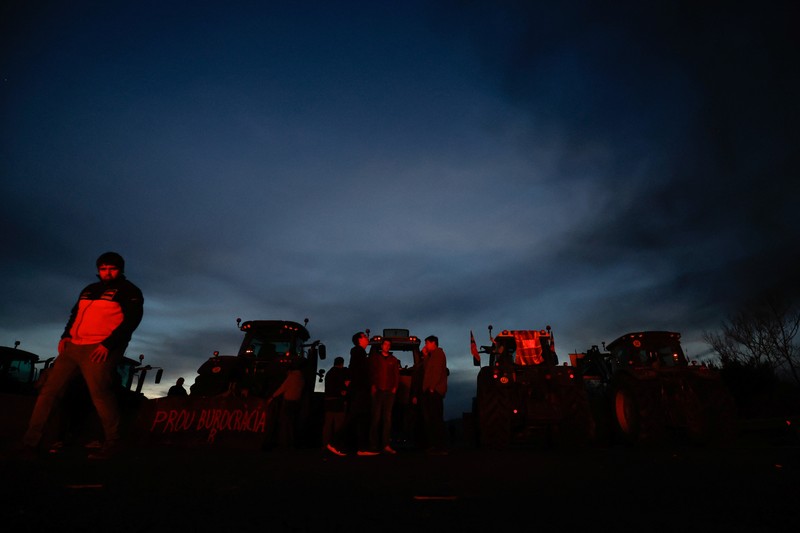 EUROPE-FARMERS/SPAIN Demonstrators stand next to tractors, as farmers block the AP-7 highway during a protest over price pressures, taxes and green regulation, grievances shared by farmers across Europe, near Girona, Spain, February 6, 2024. REUTERS/Albert Gea