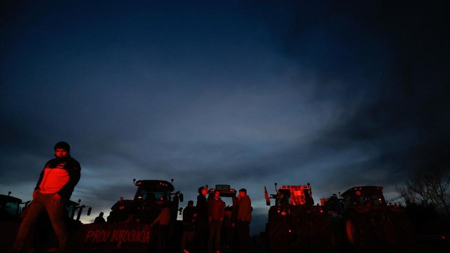 Demonstrators stand next to tractors, as farmers block the AP-7 highway during a protest over price pressures, taxes and green regulation, grievances shared by farmers across Europe, near Girona, Spain, February 6, 2024. REUTERS/Albert Gea