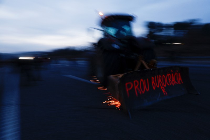 Demonstrators stand next to tractors, as farmers block the AP-7 highway during a protest over price pressures, taxes and green regulation, grievances shared by farmers across Europe, near Girona, Spain, February 6, 2024. REUTERS/Albert Gea