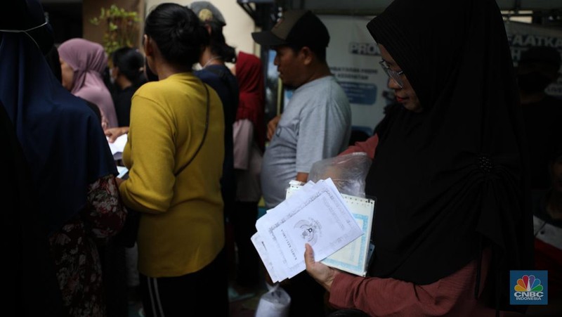 Suasana antrean warga untuk mendapatkan bantuan pangan cadangan beras berukuran 10 kg di Kantor Kelurahan Kreo Selatan, Tangerang, Banten, Rabu (7/2/2024).  (CNBC Indonesia/Tri Susilo)